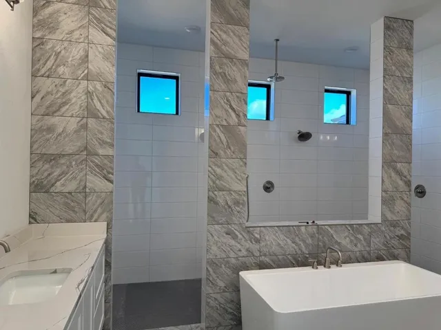 a bathroom with a sink a toilet and shower