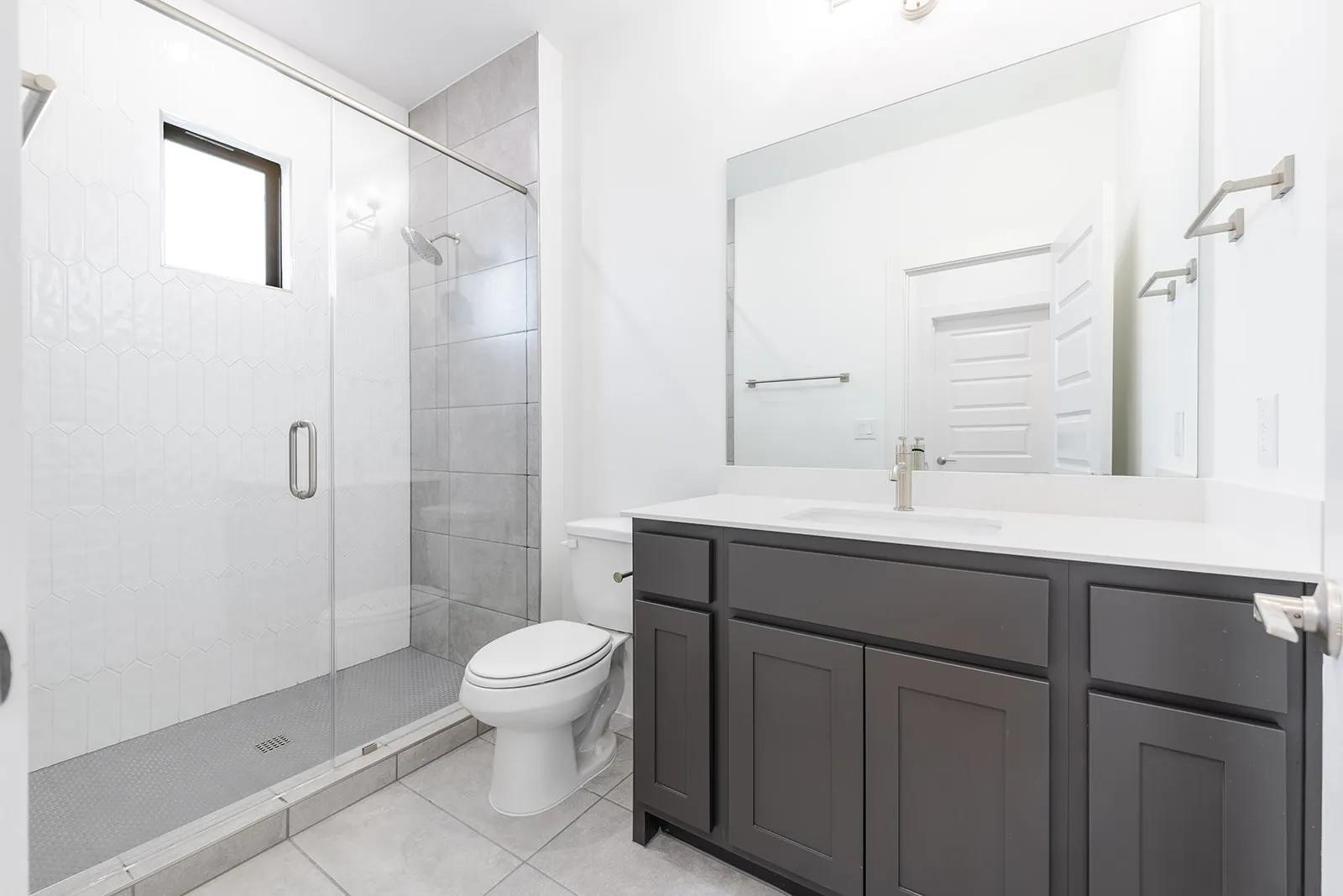 2385 Lineage Lane Leander, TX 78641 - Photo 3 of 36 a bathroom with a sink toilet a mirror and shower