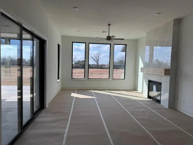 a view of an empty room with a fireplace and a window