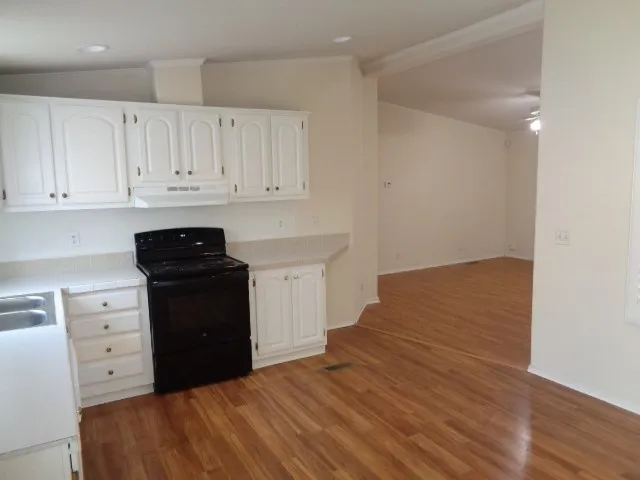 a kitchen with granite countertop white cabinets and black appliances