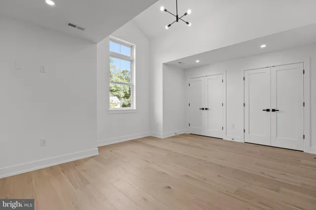 an empty room with wooden floor and window