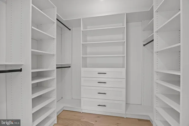 a view of walk in closet with empty racks