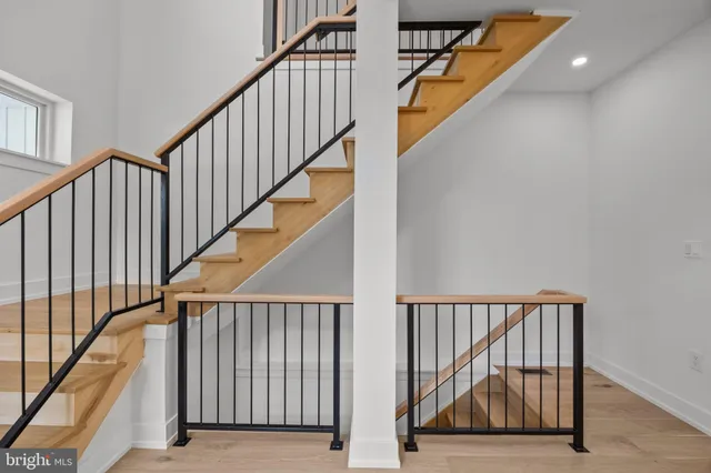 a view of staircase with railing and a window