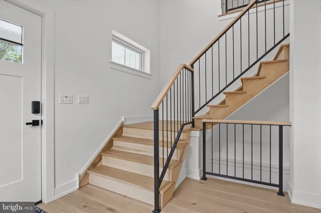 a view of staircase with railing and white walls