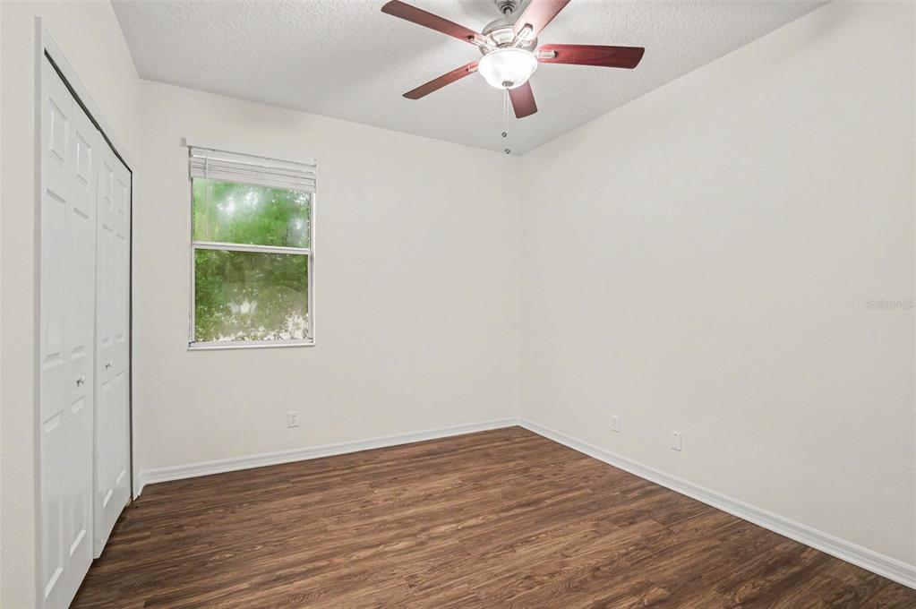 4819 Indian Deer Road Windermere, FL 34786 - Photo 16 of 30 an empty room with wooden floor chandelier fan and windows