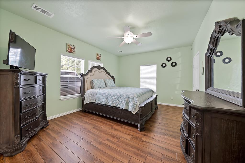 2410 Carleta Street Dallas, TX 75253 - Photo 21 of 29 a bedroom with a bed and a flat tv screen on a dresser