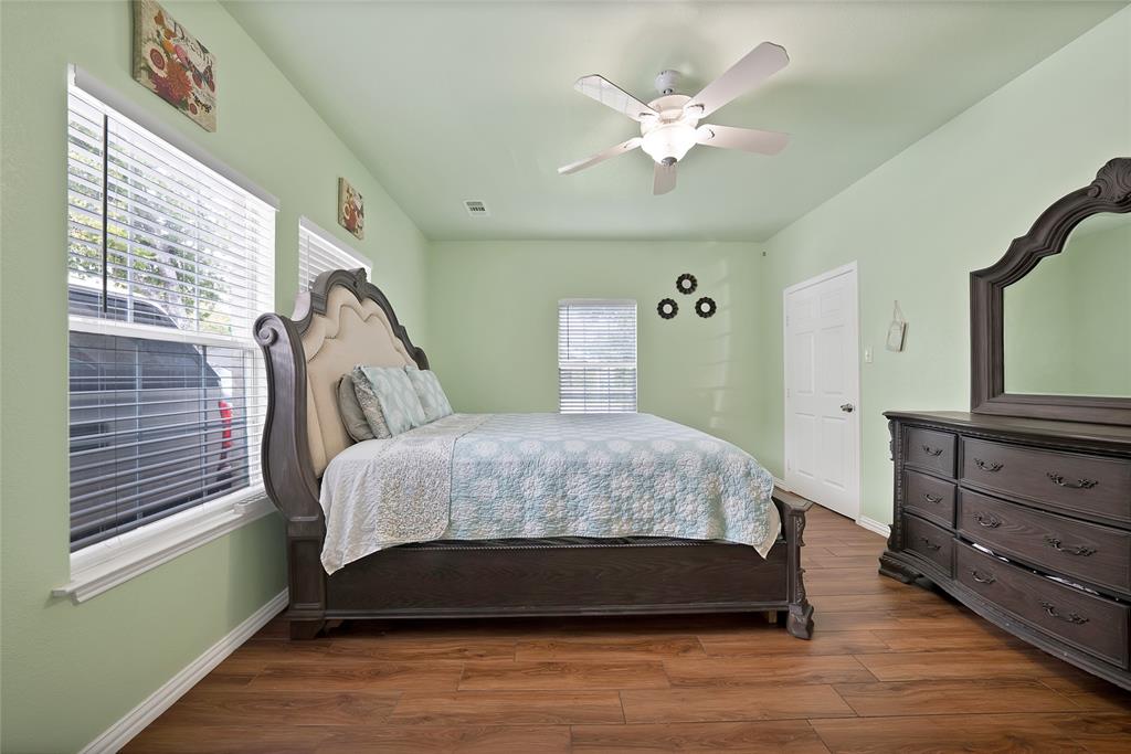 2410 Carleta Street Dallas, TX 75253 - Photo 24 of 29 a bedroom with a large bed and a chandelier
