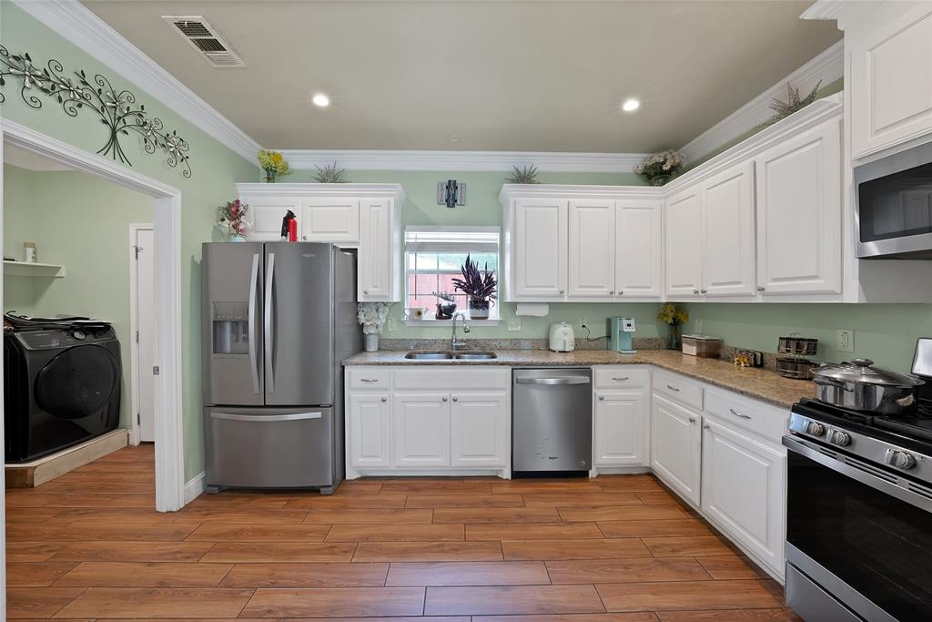 2410 Carleta Street Dallas, TX 75253 - Photo 10 of 29 a kitchen with a refrigerator and a stove top oven