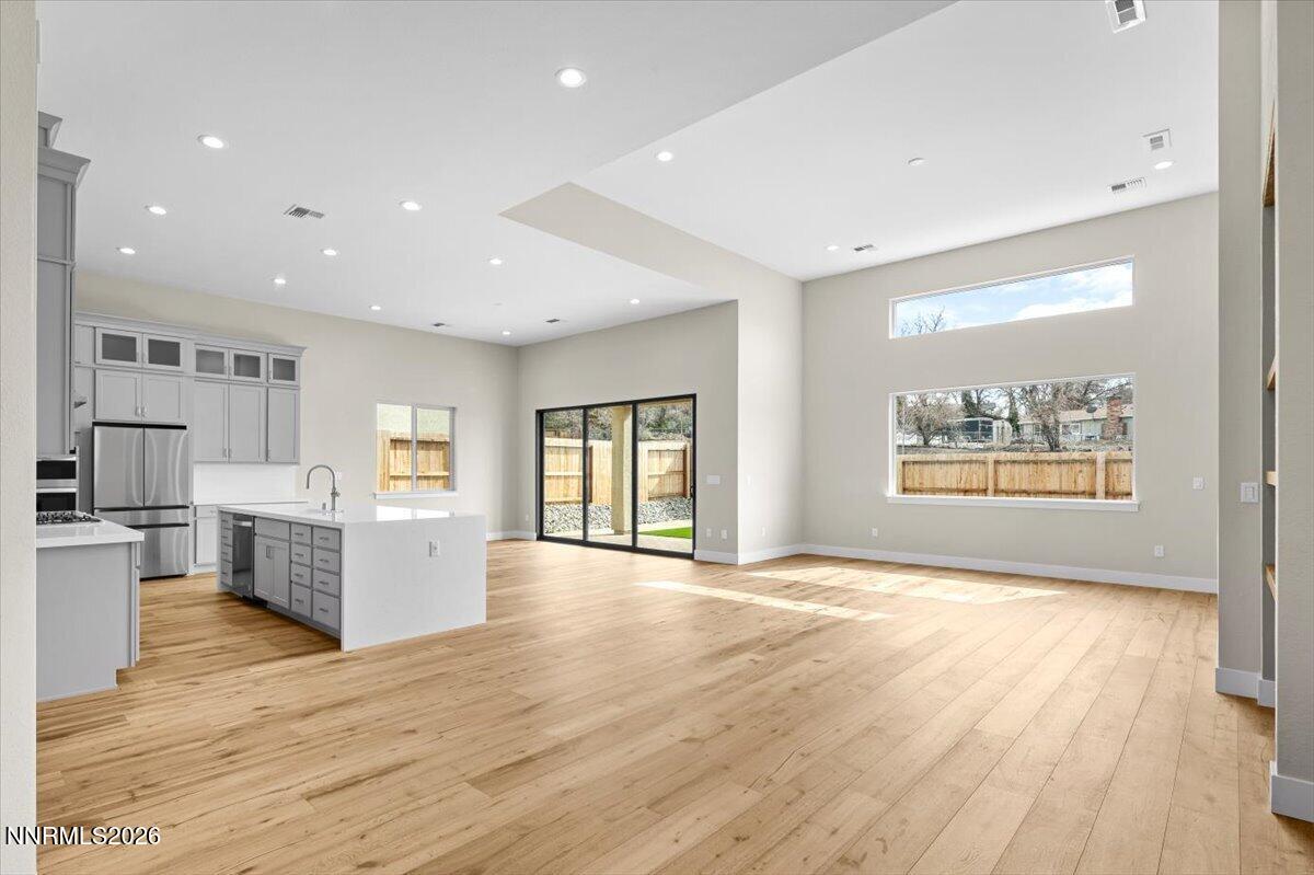 2982 Saddle Peak Drive Reno, NV 89521 - Photo 31 of 98 a view of an empty room and kitchen with wooden floor