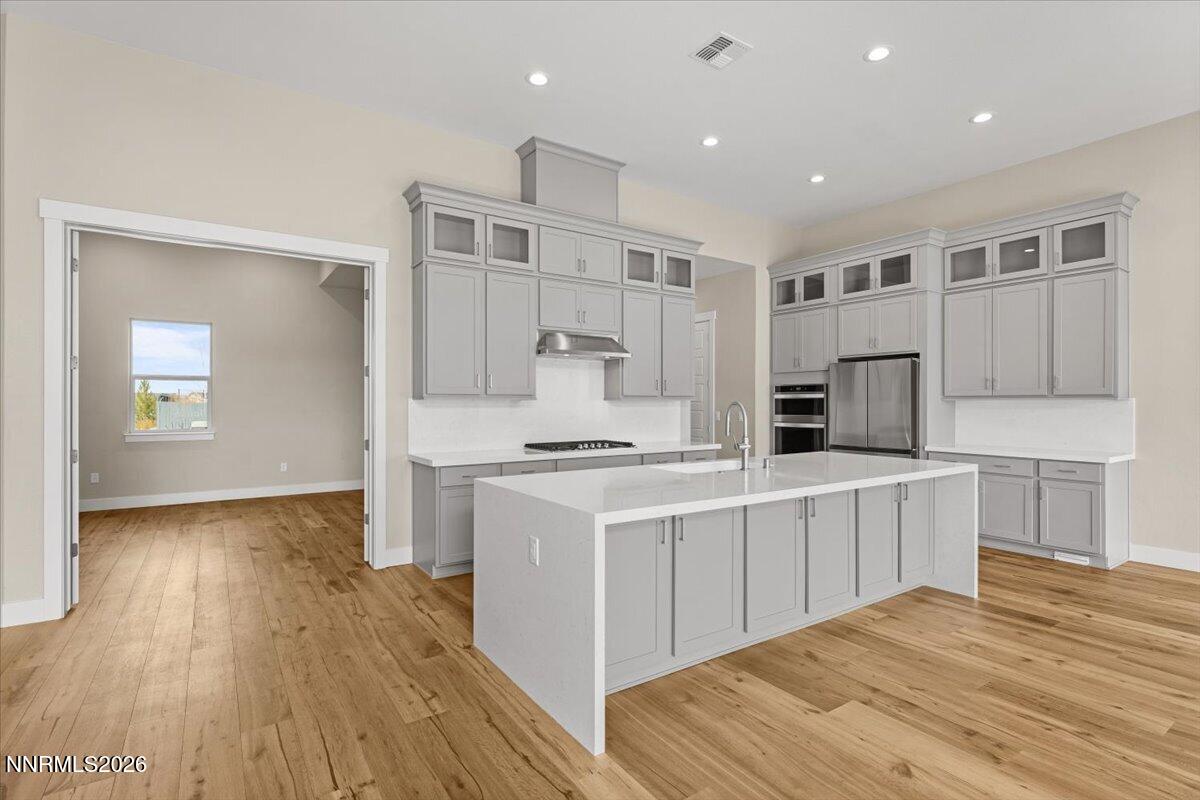 2982 Saddle Peak Drive Reno, NV 89521 - Photo 37 of 98 a kitchen with stainless steel appliances granite countertop a stove top oven a sink dishwasher and a refrigerator with wooden floor