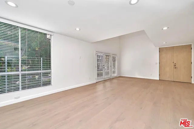 an empty room with wooden floor and entryway