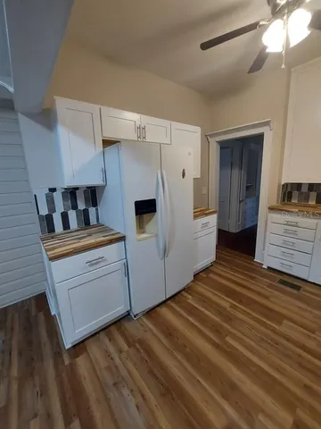 a kitchen with cabinets and wooden floor