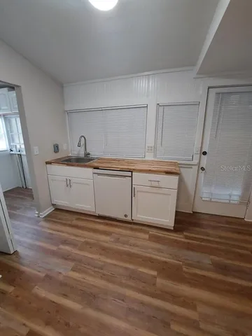 a view of a kitchen with sink and wooden floor
