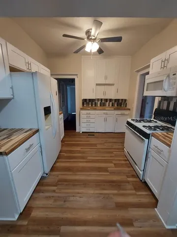 a kitchen with wooden floors and appliances