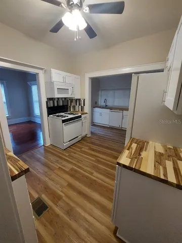 a kitchen with granite countertop a sink cabinets and stainless steel appliances