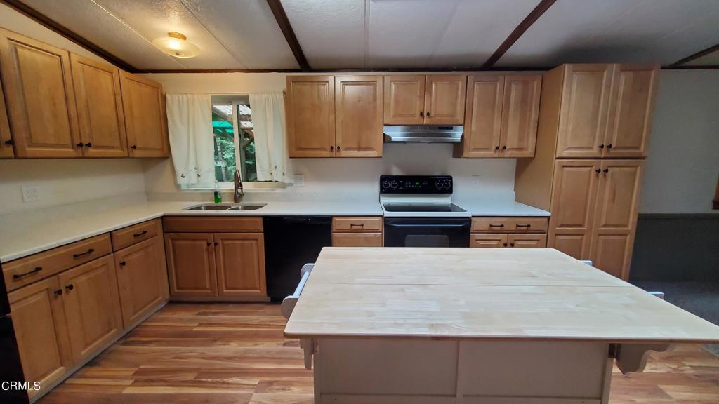 a kitchen with kitchen island granite countertop wooden cabinets a sink and dishwasher