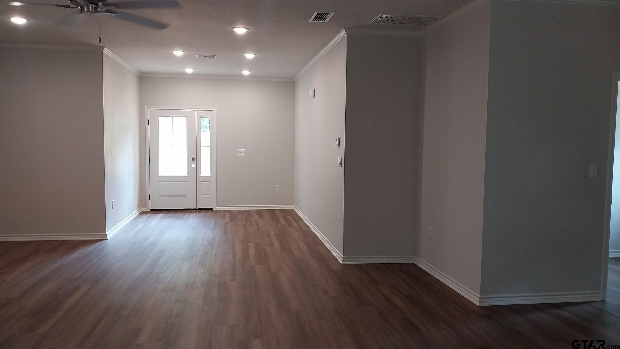 1262 George Richey Road Gladewater, TX 75647 - Photo 3 of 22 an empty room with wooden floor and windows