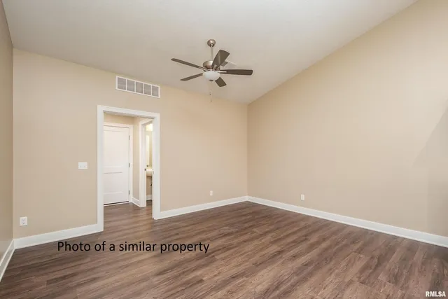 a view of room with hardwood floor and a ceiling fan