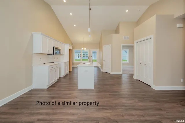 a view of a kitchen with kitchen island a sink stainless steel appliances and cabinets