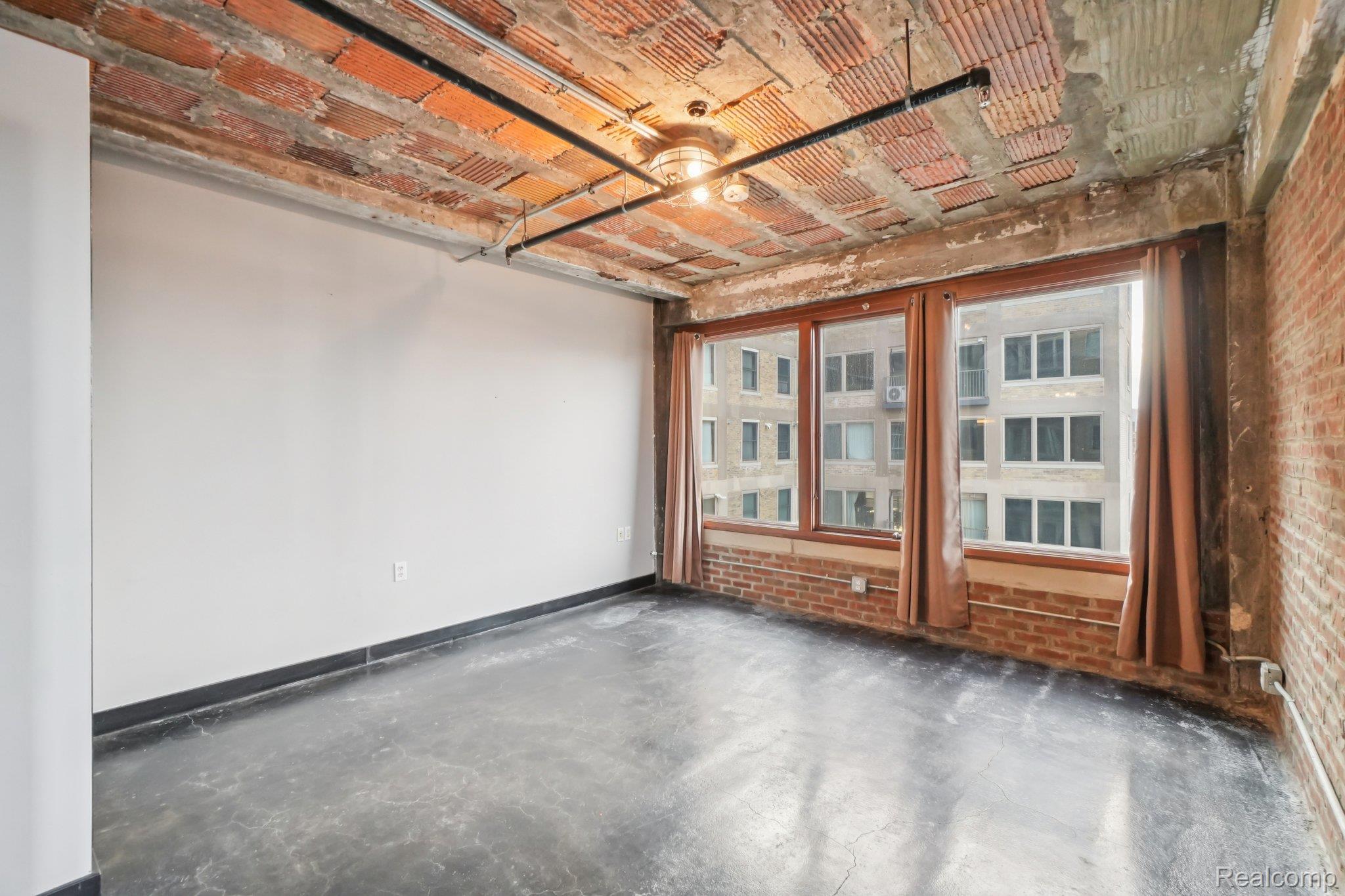 2915 John R Street Detroit, MI 48201 - Photo 14 of 30 Spare room with brick wall and concrete flooring