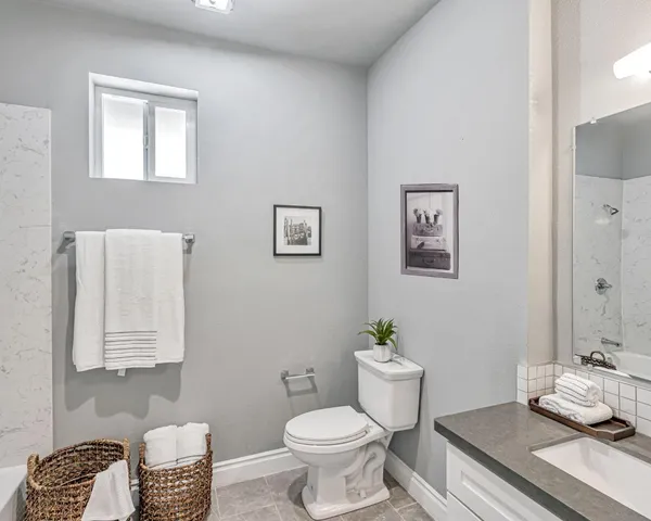 a bathroom with a granite countertop toilet and a sink