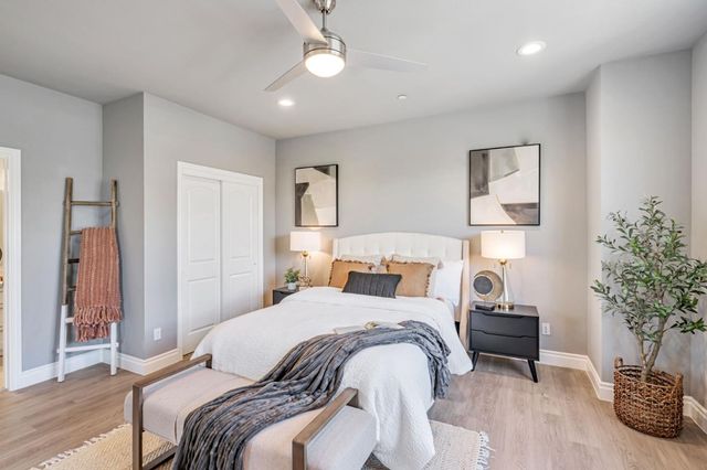 a bedroom with a bed and a potted plant