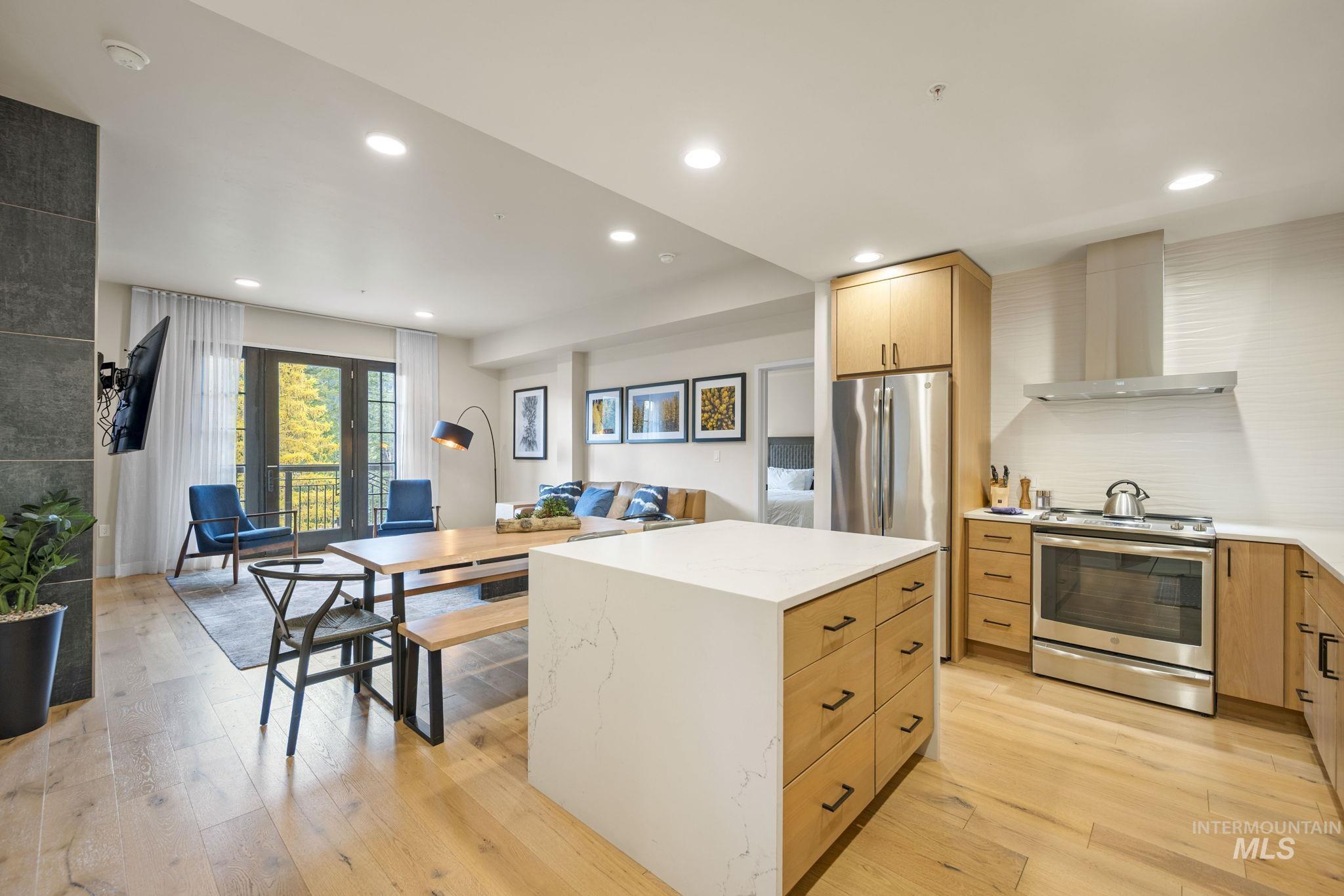 780 Village Drive, Unit 505 Donnelly, ID 83615 - Photo 10 of 33 Kitchen with stainless steel electric range oven, wall chimney range hood, recessed lighting, light wood-type flooring, and a kitchen island