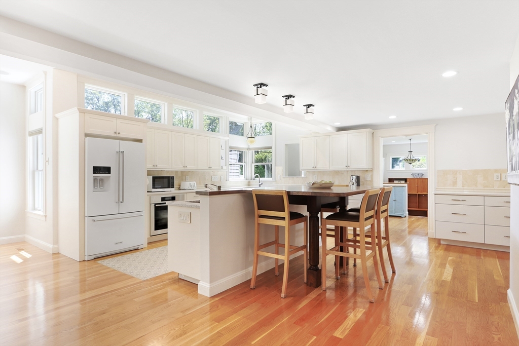 66 Avalon Road Needham, MA 02492 - Photo 5 of 39 a kitchen with stainless steel appliances kitchen island granite countertop a table chairs and a refrigerator