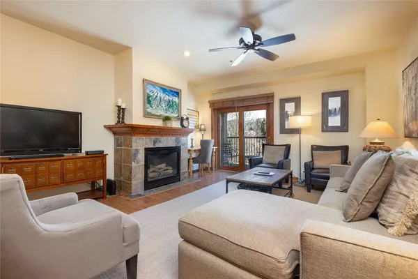 a living room with furniture a flat screen tv and a fireplace