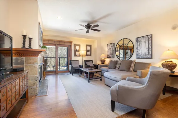 a living room with furniture a fireplace and a large window