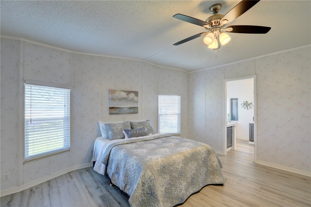 7519 Chasta Road Micco, FL 32976 - Photo 13 of 27 a bedroom with a large bed and a chandelier