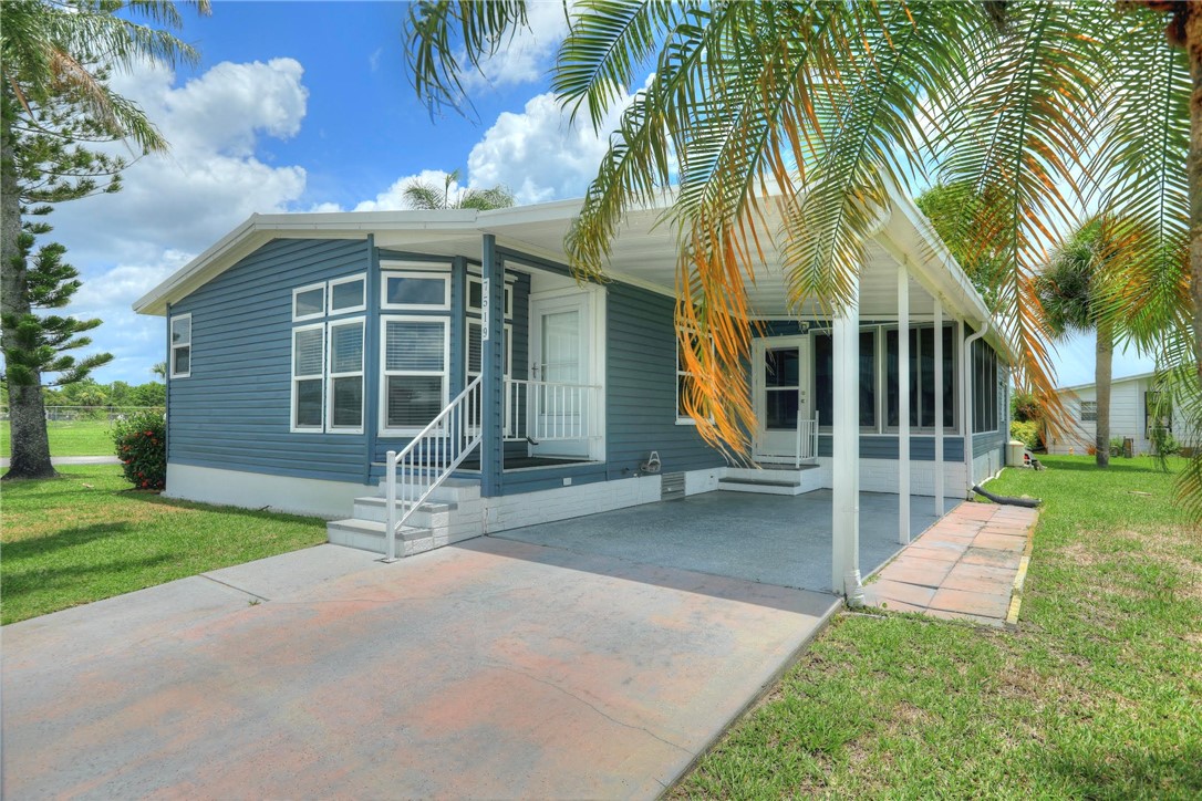 7519 Chasta Road Micco, FL 32976 - Photo 4 of 27 a front view of a house with a yard and porch