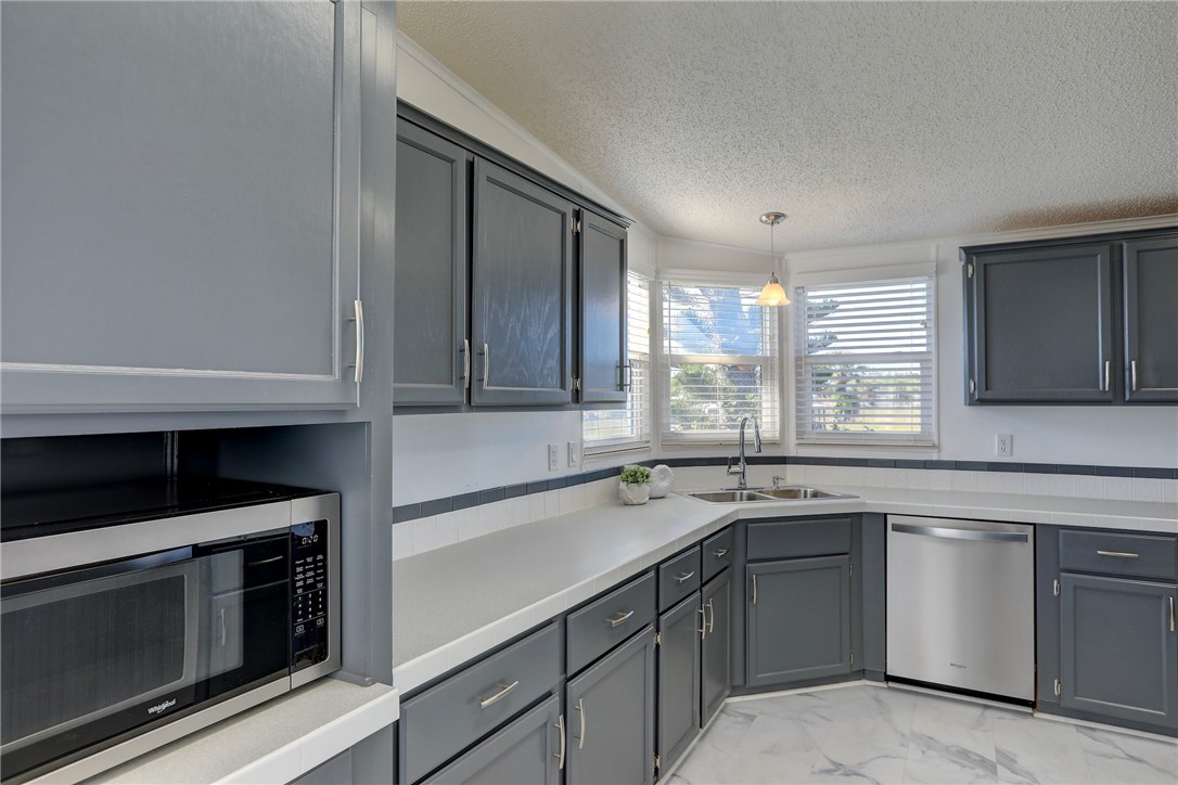7519 Chasta Road Micco, FL 32976 - Photo 9 of 27 a kitchen with a sink stove and microwave