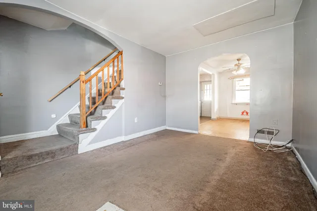a view of an empty room with stairs and a window