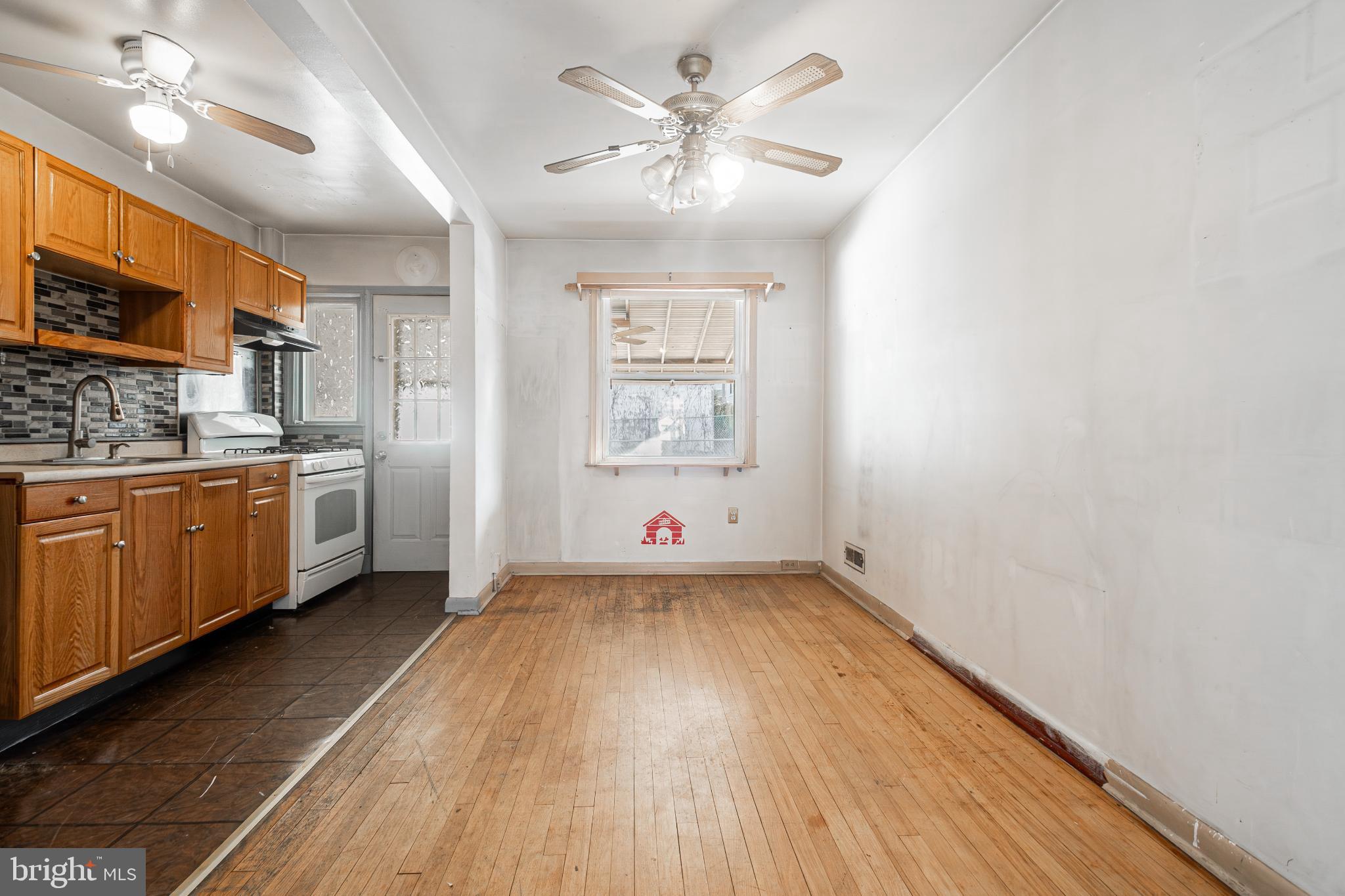 1217 Anglesea Street Baltimore, MD 21224 - Photo 5 of 25 a view of a kitchen with a sink dishwasher a kitchen with wooden floor and a window