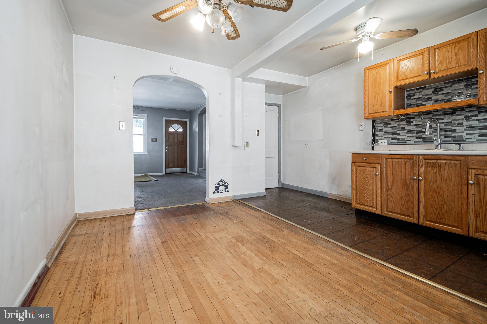 1217 Anglesea Street Baltimore, MD 21224 - Photo 6 of 25 a view of room with kitchen island wooden floor and ceiling fan