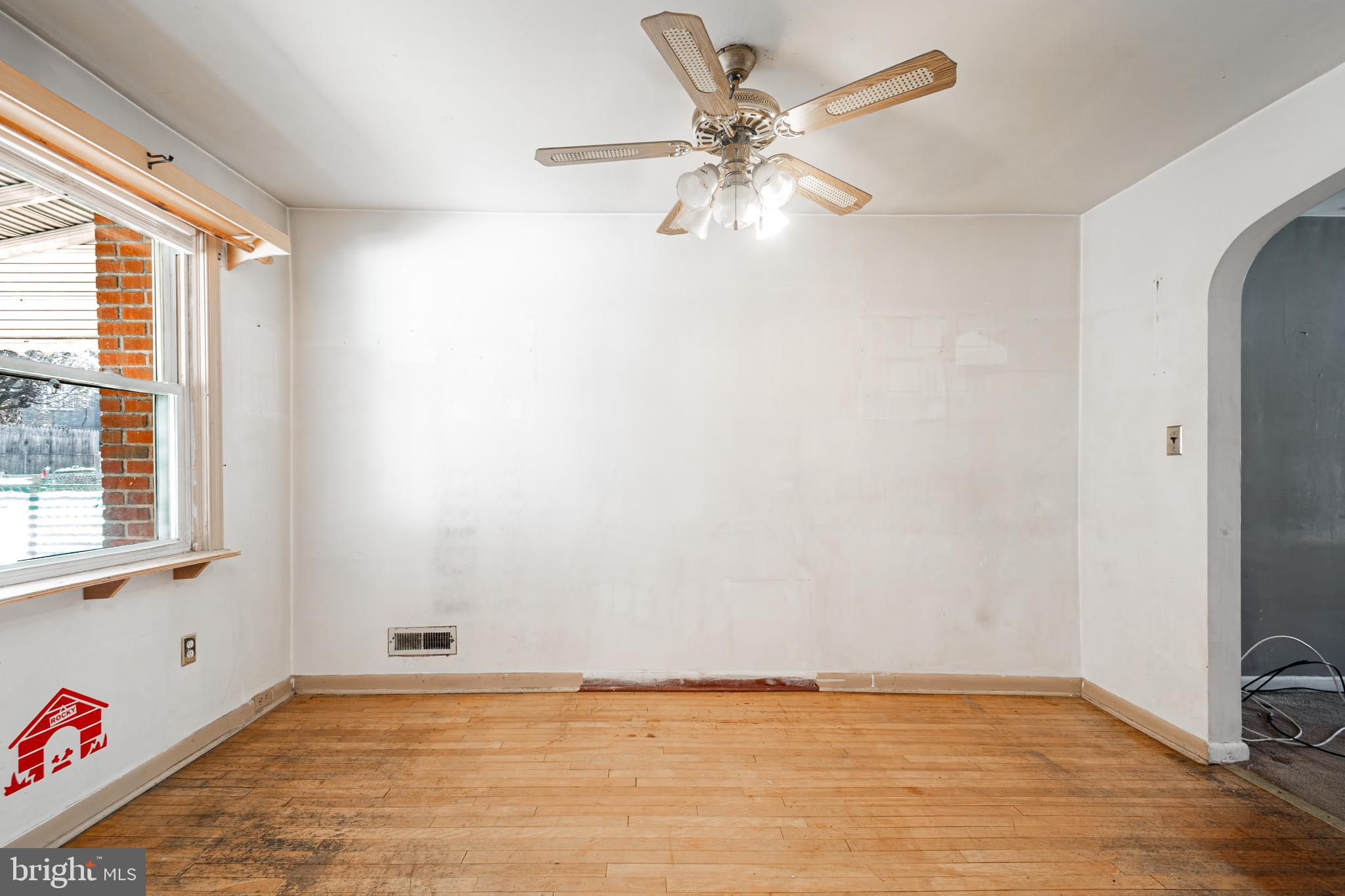 1217 Anglesea Street Baltimore, MD 21224 - Photo 10 of 25 a view of an empty room with a window and wooden floor