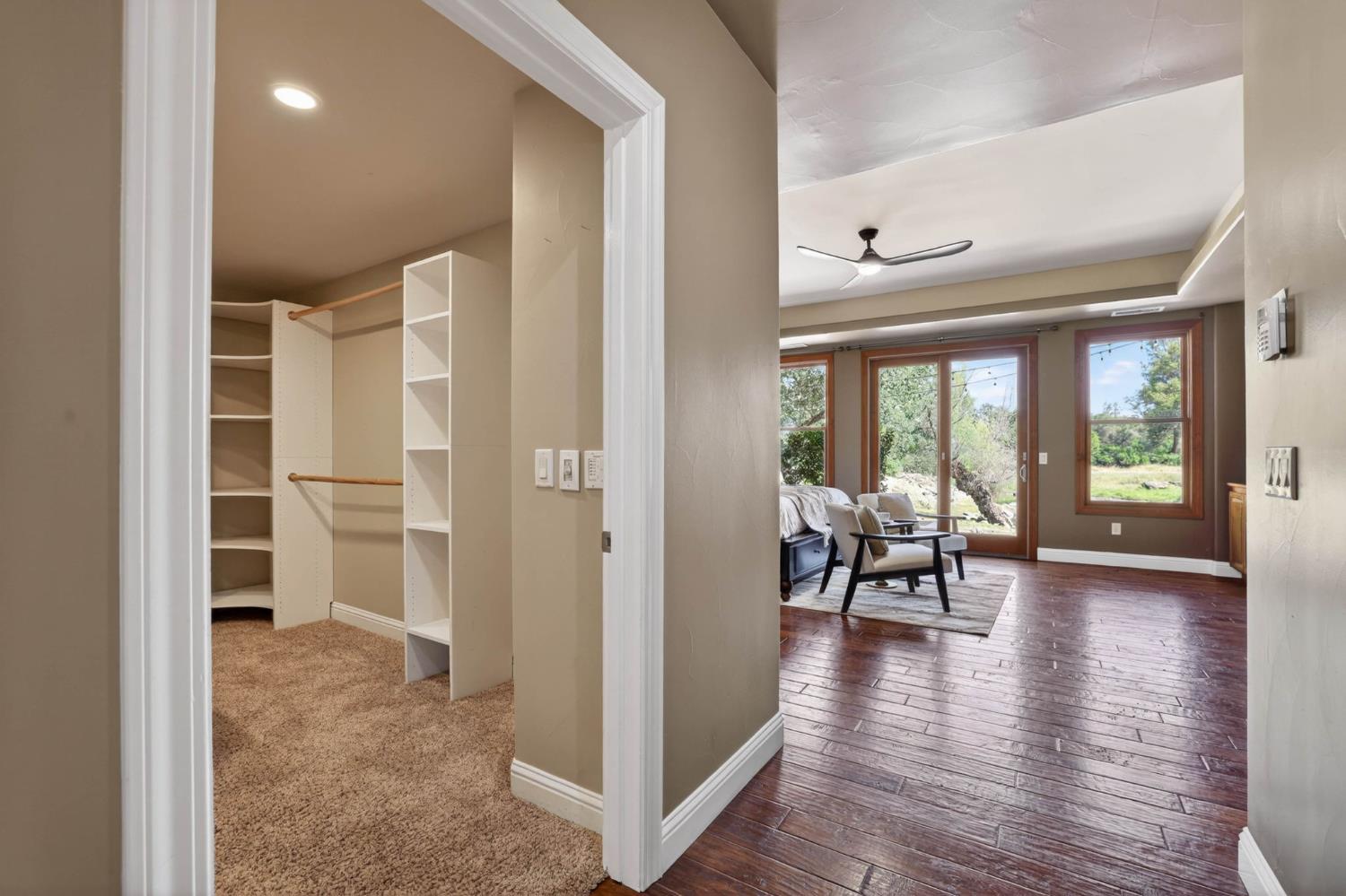 7021 Horseshoe Bar Road Loomis, CA 95650 - Photo 19 of 77 View of the light-filled primary suite with coffered ceilings, radiant heated floors, and a calming pond views offering direct access to the spacious walk-in closet.
