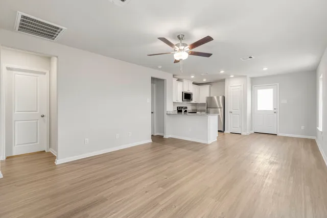 a view of a kitchen with a sink a refrigerator and wooden floor