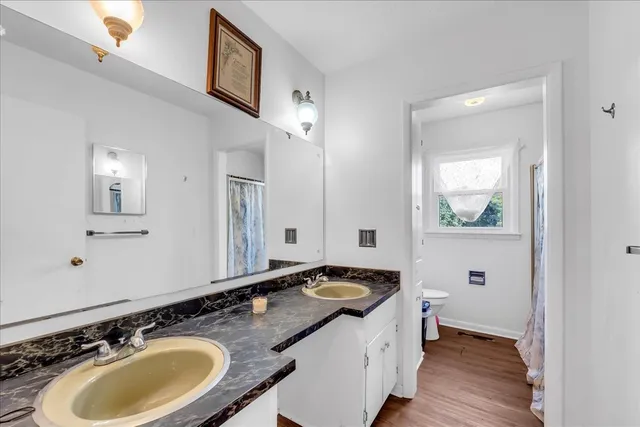 a bathroom with a toilet sink and mirror