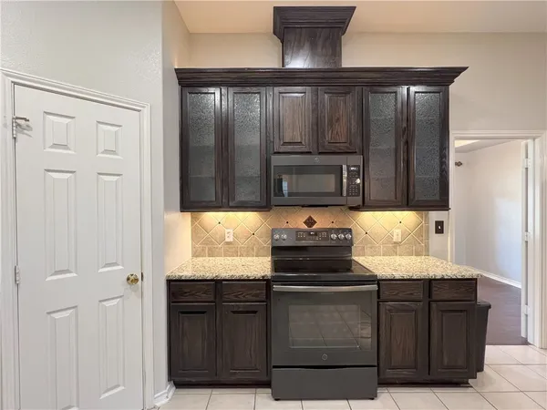 a kitchen with granite countertop stainless steel appliances a sink and a refrigerator