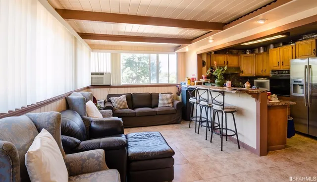 a living room with furniture a fireplace and a large window