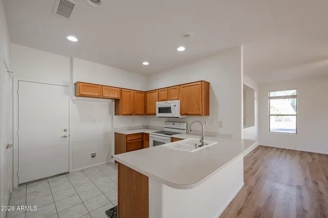 a kitchen with stainless steel appliances granite countertop a sink and a refrigerator