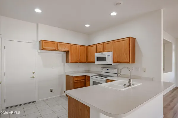 a kitchen with stainless steel appliances granite countertop a sink and a refrigerator