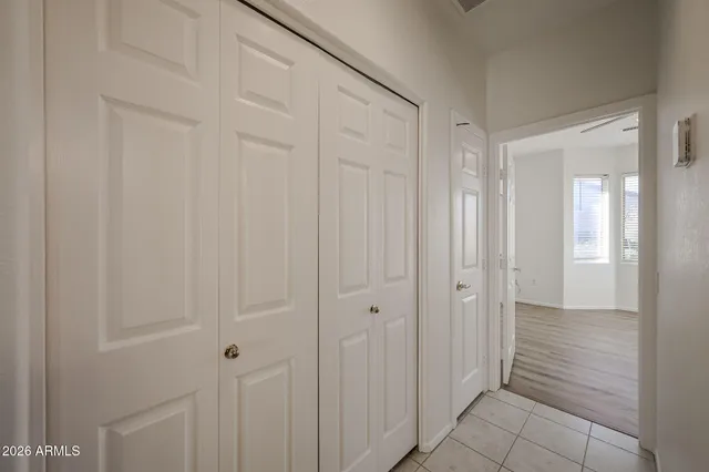 an empty room with wooden floor ceiling fan and window