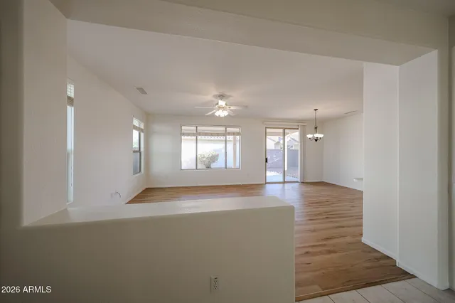 a view of an empty room with window and wooden floor