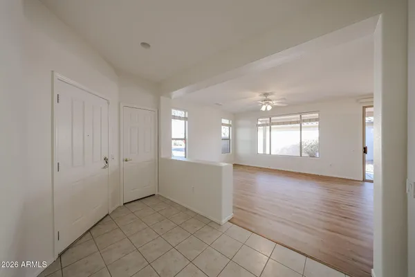 a view of an empty room with window and wooden floor