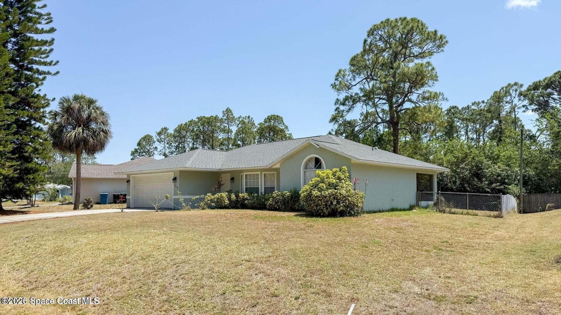 544 Plumbago Road Northwest Palm Bay, FL 32907 - Photo 2 of 14 a front view of a house with a yard and potted plants
