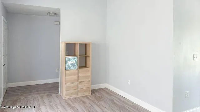 a view of an empty room with wooden floor