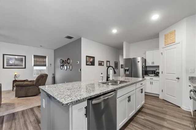 a kitchen with stainless steel appliances granite countertop a kitchen island a stove and a sink